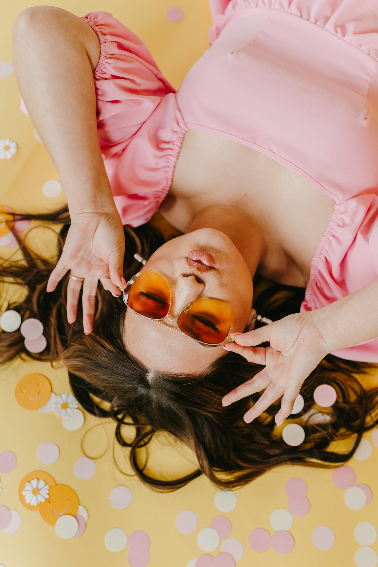 Kay Marie in her signature pink dress against a yellow backdrop